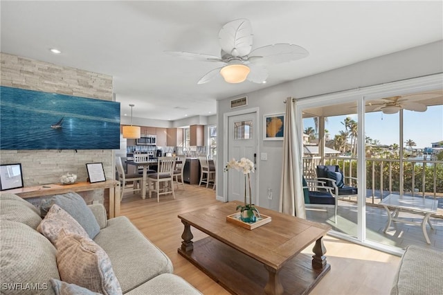 living room with ceiling fan and light wood-type flooring