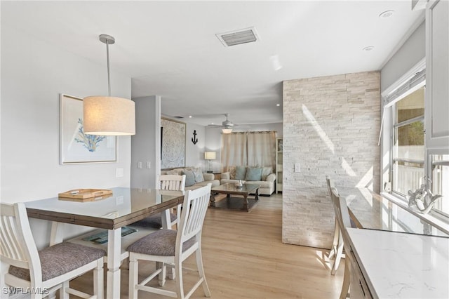 dining room with ceiling fan and light hardwood / wood-style floors