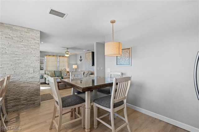 dining area with ceiling fan and light hardwood / wood-style flooring