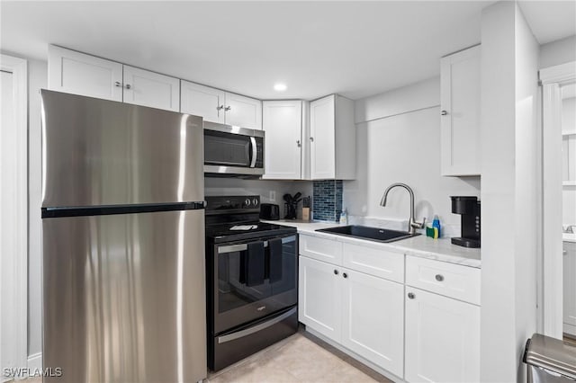 kitchen with a sink, decorative backsplash, light countertops, white cabinets, and stainless steel appliances