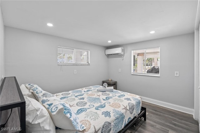 bedroom with dark hardwood / wood-style floors and an AC wall unit