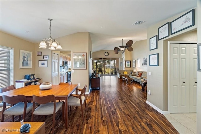 dining space with a healthy amount of sunlight, light hardwood / wood-style flooring, lofted ceiling, and ceiling fan with notable chandelier