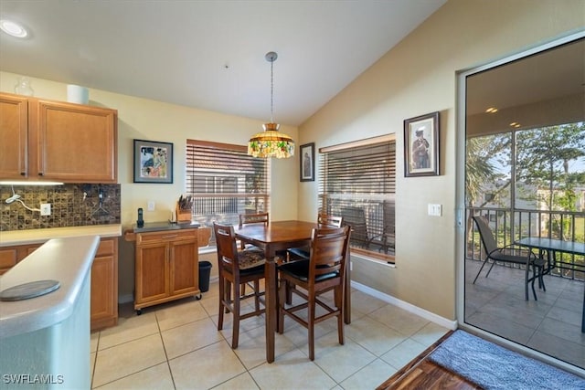 tiled dining space featuring vaulted ceiling