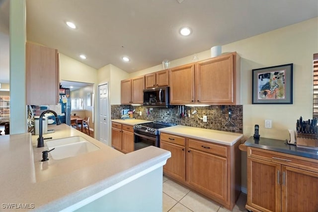 kitchen featuring stainless steel appliances, sink, lofted ceiling, light tile patterned floors, and tasteful backsplash