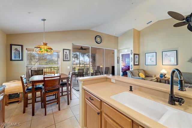 kitchen with sink, light tile patterned floors, vaulted ceiling, and pendant lighting