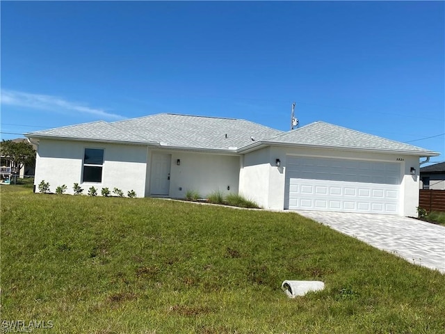 single story home with a garage and a front lawn