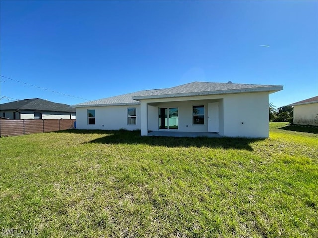 rear view of house featuring a yard