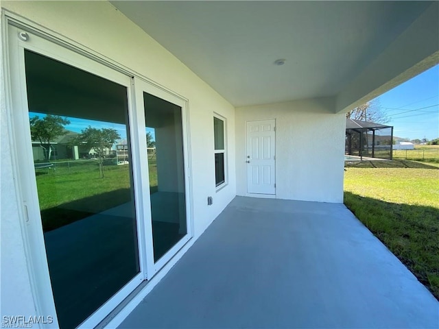 view of patio featuring glass enclosure