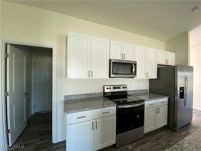 kitchen with white cabinetry, stainless steel appliances, dark wood-type flooring, and light stone counters