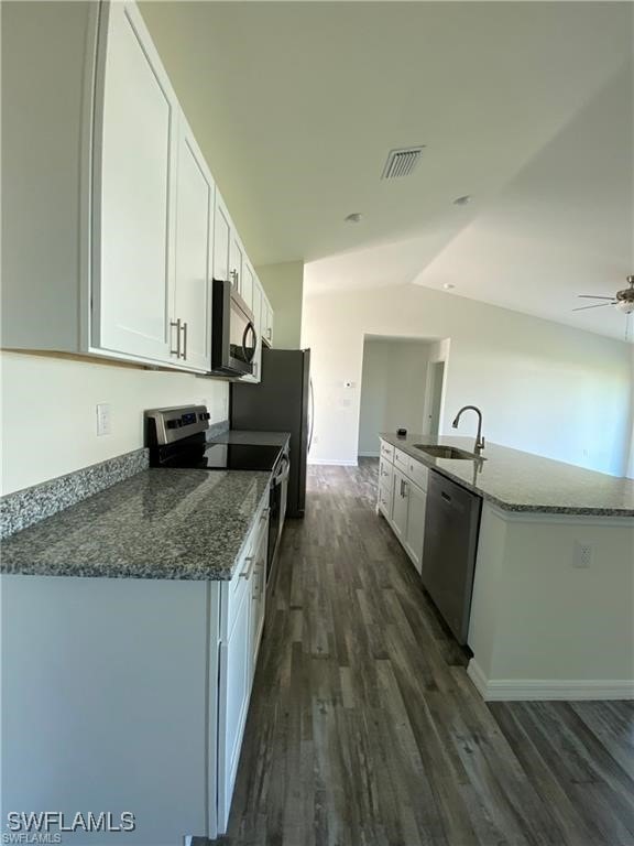 kitchen with dark stone countertops, sink, white cabinets, and appliances with stainless steel finishes