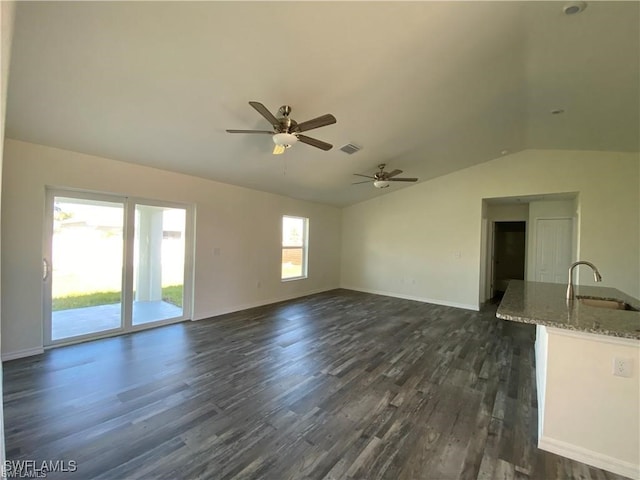 unfurnished living room with lofted ceiling, sink, dark wood-type flooring, and ceiling fan