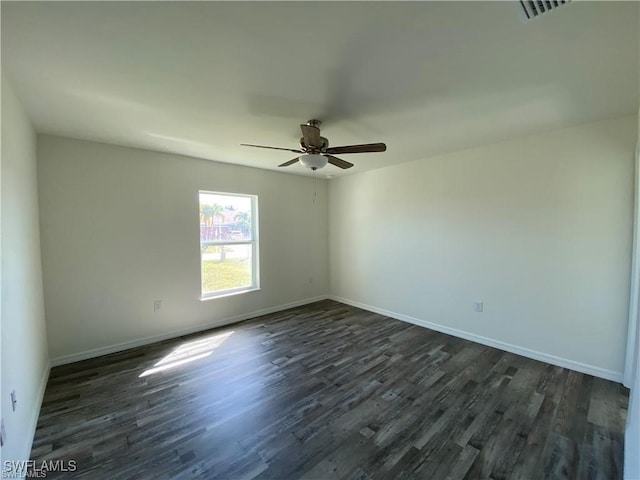 spare room with dark hardwood / wood-style flooring and ceiling fan