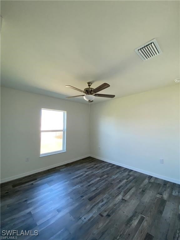 spare room featuring ceiling fan and dark hardwood / wood-style flooring