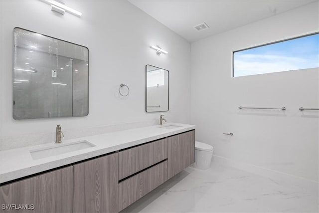 bathroom featuring vanity, toilet, and a shower