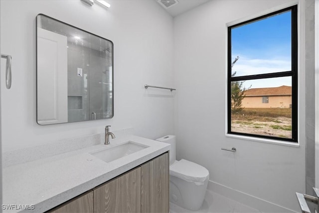 bathroom with vanity, a shower with shower door, and toilet