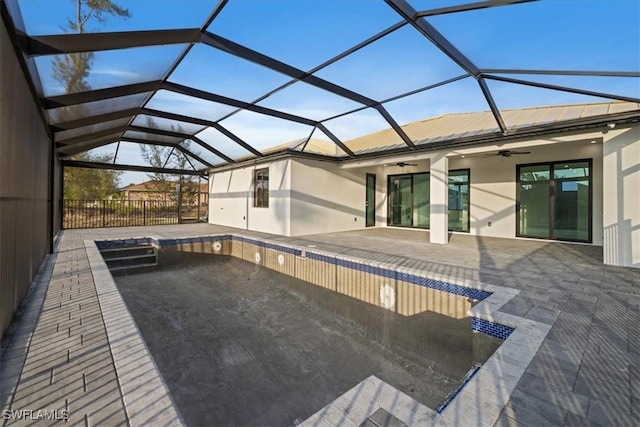 view of swimming pool with ceiling fan, a lanai, and a patio area