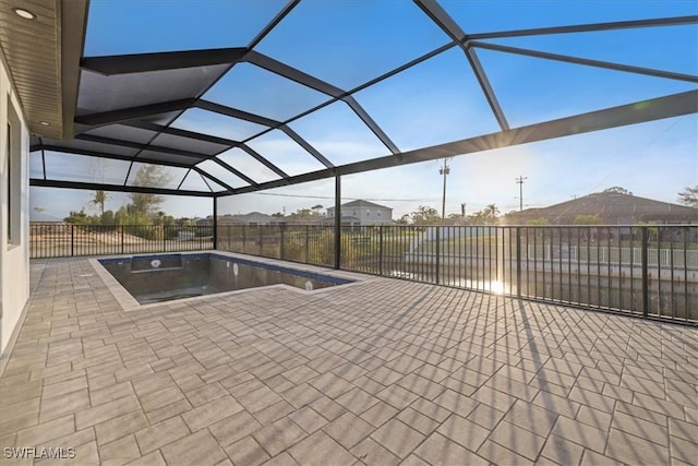 view of swimming pool featuring a patio area and glass enclosure