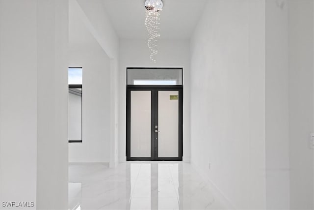 entryway featuring an inviting chandelier and french doors