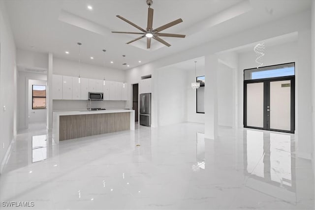 kitchen with white cabinetry, pendant lighting, stainless steel appliances, and a spacious island