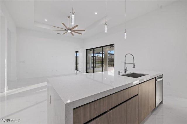 kitchen with pendant lighting, sink, ceiling fan, a tray ceiling, and a spacious island