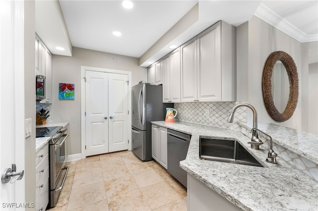 kitchen featuring light stone countertops, appliances with stainless steel finishes, backsplash, and sink