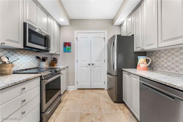 kitchen featuring white cabinetry, appliances with stainless steel finishes, and tasteful backsplash