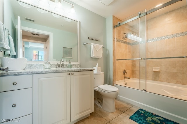 full bathroom featuring tile patterned floors, vanity, toilet, and bath / shower combo with glass door