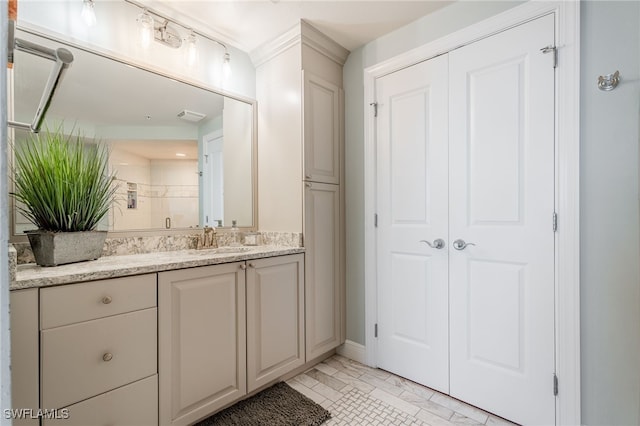 bathroom featuring a shower with door and vanity