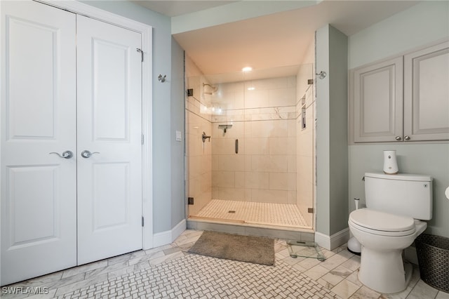 bathroom featuring toilet and an enclosed shower