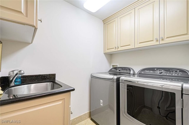 washroom featuring sink, washer and dryer, and cabinets