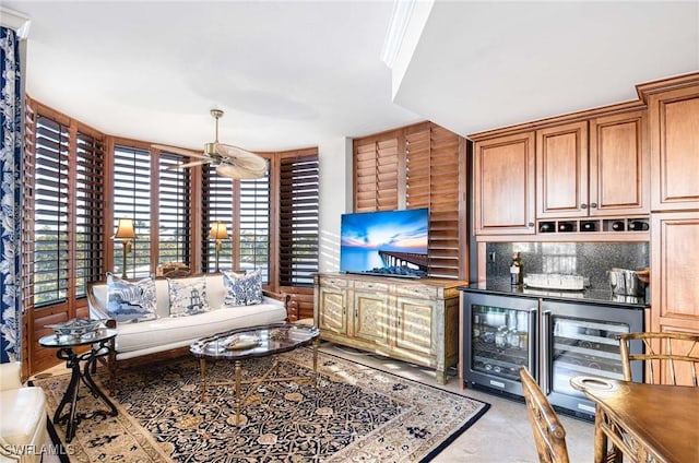 living room featuring a healthy amount of sunlight, ceiling fan, and bar