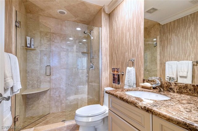 bathroom featuring ornamental molding, an enclosed shower, vanity, and toilet