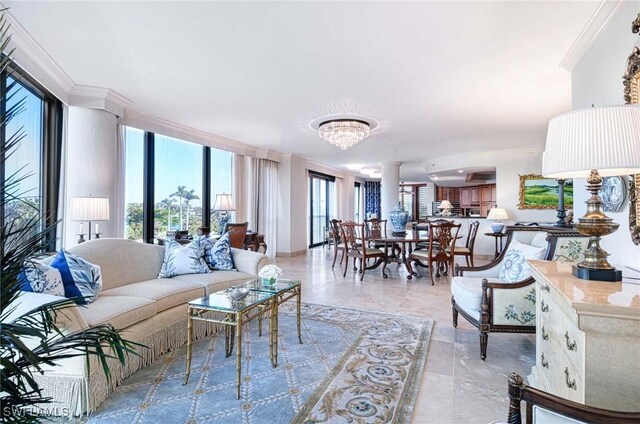 living room featuring ornamental molding, a notable chandelier, and plenty of natural light