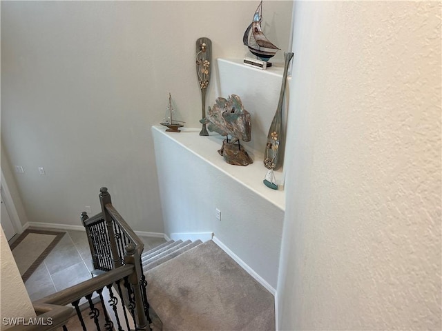 staircase featuring tile patterned floors and baseboards