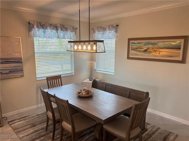 tiled dining space featuring plenty of natural light, crown molding, and baseboards