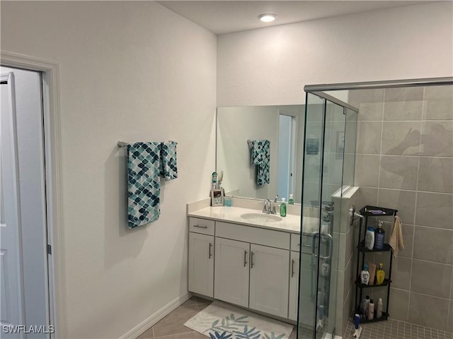 full bath with tile patterned flooring, baseboards, a shower stall, and vanity