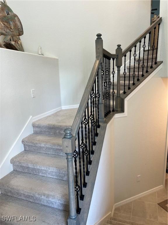 stairs featuring tile patterned flooring and baseboards