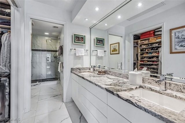 bathroom featuring a shower with shower door and vanity