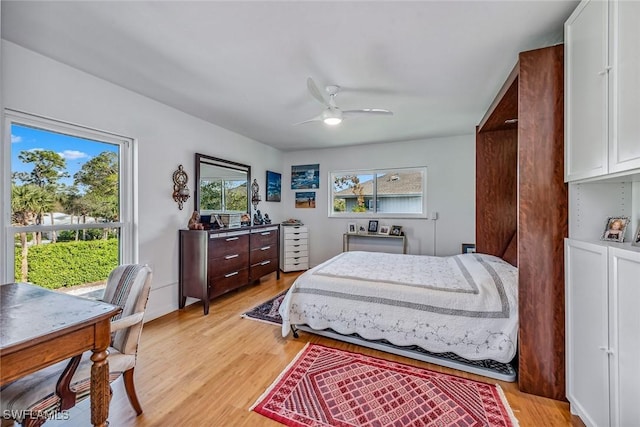 bedroom with multiple windows, ceiling fan, and light hardwood / wood-style flooring