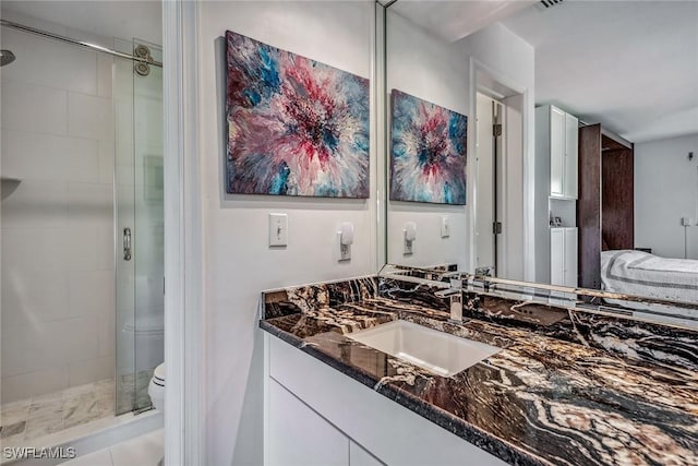 bathroom with vanity, toilet, walk in shower, and tile patterned floors