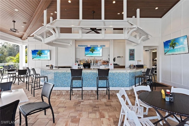 dining area featuring a high ceiling, ceiling fan, wood ceiling, and beam ceiling