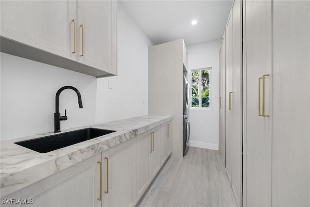 kitchen featuring light stone counters and sink