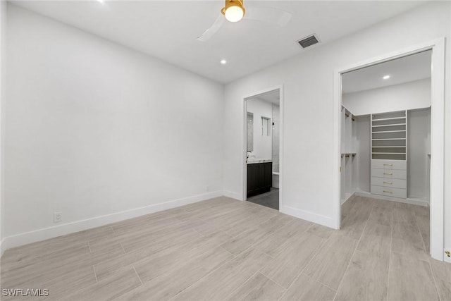 unfurnished bedroom with ceiling fan, a closet, and a spacious closet