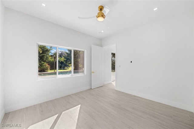 empty room with ceiling fan and light wood-type flooring