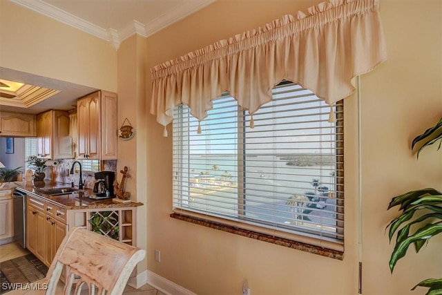 kitchen with sink, stainless steel dishwasher, light brown cabinetry, and crown molding