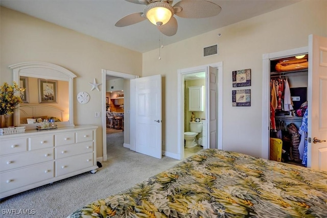 bedroom with ensuite bathroom, a closet, a walk in closet, ceiling fan, and light carpet