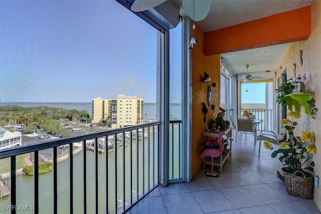 balcony featuring ceiling fan and a water view