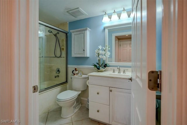 full bathroom featuring toilet, vanity, tile patterned flooring, and enclosed tub / shower combo