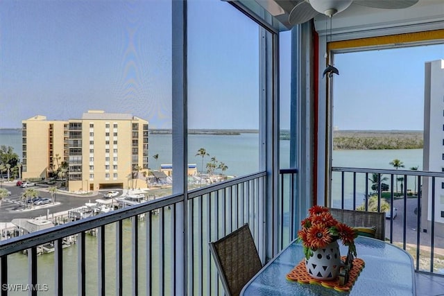 balcony with ceiling fan and a water view