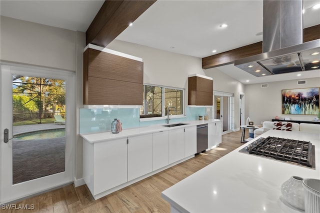 kitchen with island range hood, stainless steel appliances, light hardwood / wood-style floors, white cabinets, and sink